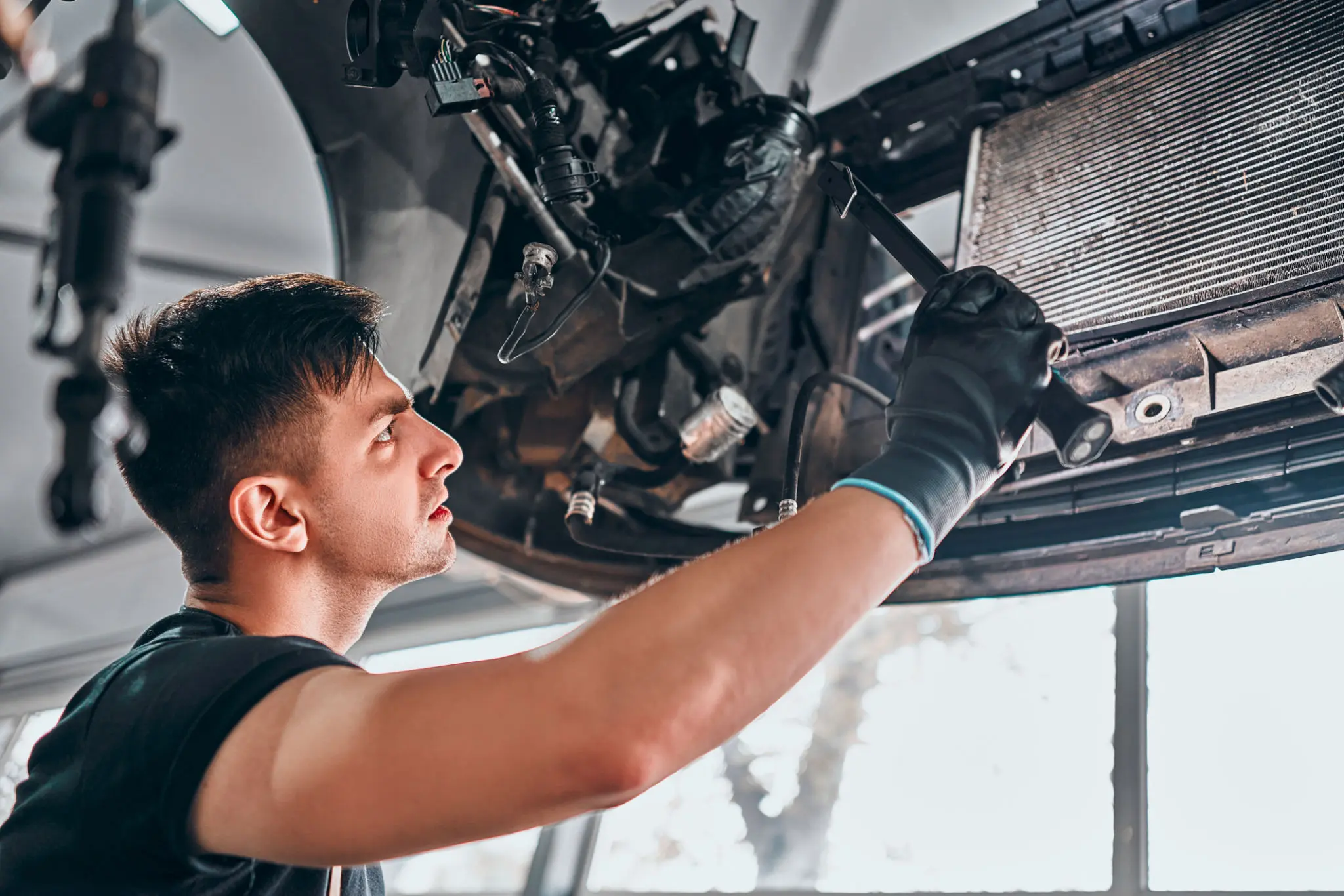 Mechanic working on car engine repair.