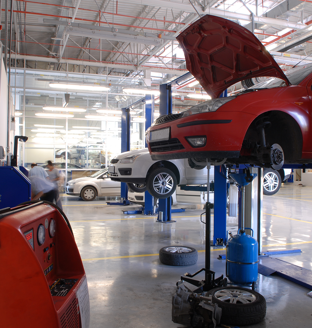Cars on lifts in auto repair shop.
