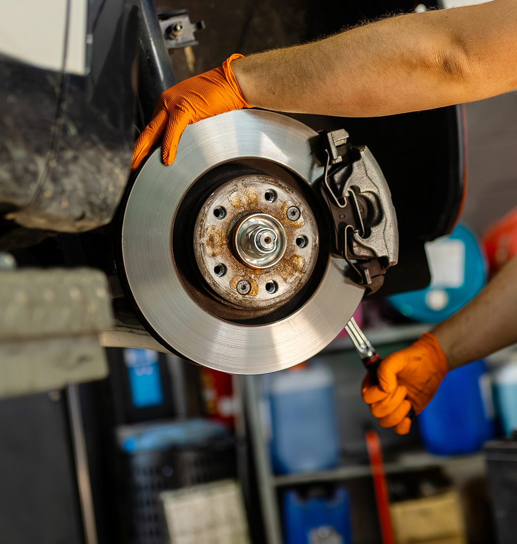 Mechanic working on car brake system.