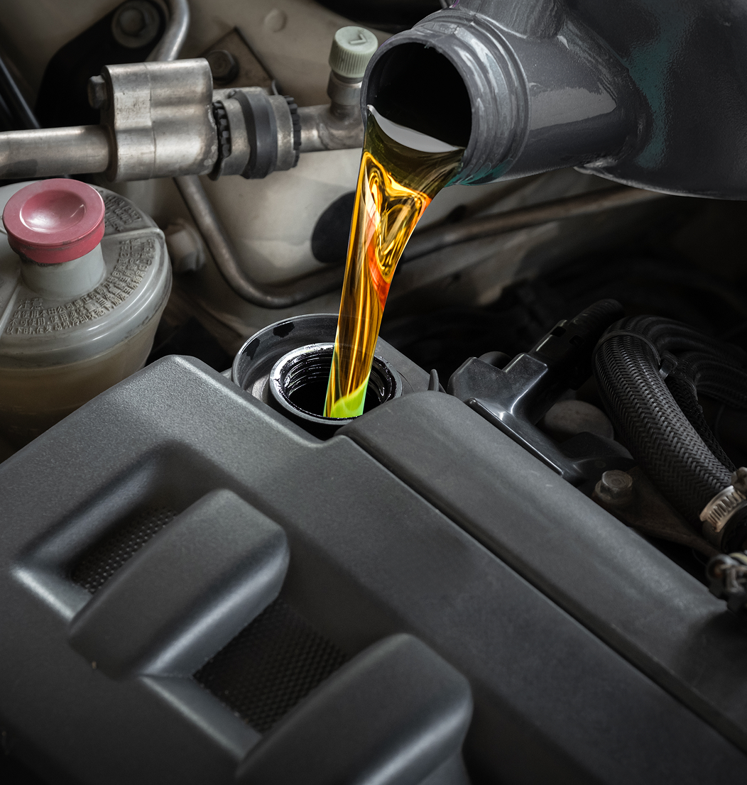 Pouring engine oil into car engine.