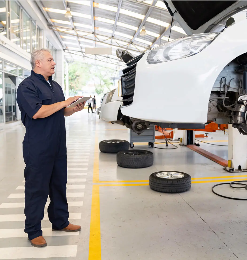 Mechanic inspecting car in auto repair shop.